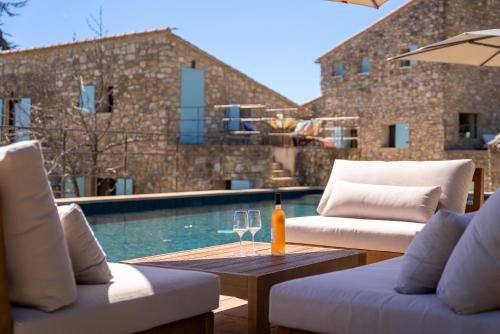 - une terrasse avec 2 chaises et une table avec une bouteille de vin dans l'établissement Evasion Luberon, à Murs