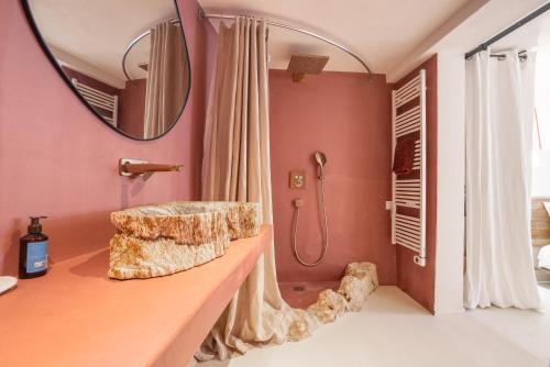 une salle de bain avec un lavabo et une douche avec un miroir dans l'établissement Evasion Luberon, à Murs