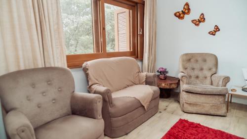 a living room with two chairs and a couch at Otimo apto c WiFi, ar-condicionado e garagem in Uruguaiana