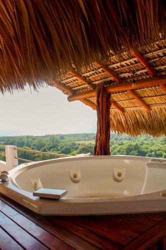 a bath tub under a straw umbrella on a deck at Penthouse vistamar puerto escondido in Puerto Escondido