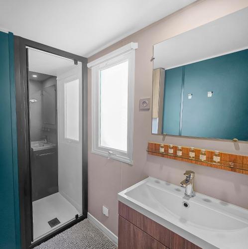 une salle de bain avec un lavabo et une douche dans l'établissement le Nomatitoz, à Litteau