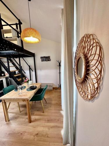 une salle à manger avec une table en bois et des chaises vertes dans l'établissement Douce Parenthèse, à Roanne
