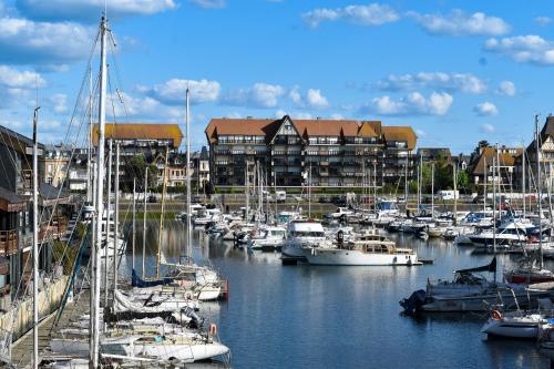 a bunch of boats docked in a marina with buildings at Bel appartement à Deauville - vue mer et port in Deauville