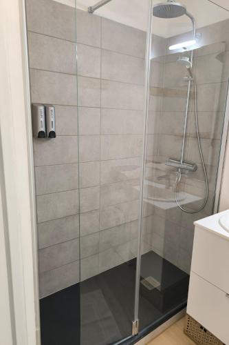 une douche avec une porte vitrée dans une salle de bain dans l'établissement Appartement vue imprenable montagne, à Samoëns