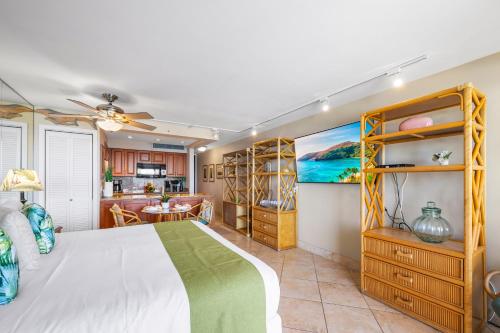 Un dormitorio con una cama y una cocina. en Mahana 913, en Kahana