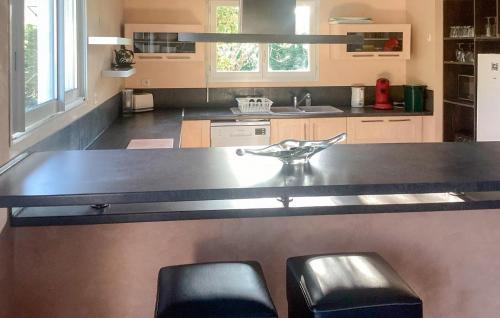 une cuisine avec un grand comptoir et deux tabourets dans l'établissement Lovely Home In Vensac, à Vensac