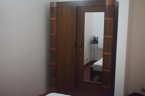 een houten kast met een spiegel in een kamer bij Villa Green Garden in Hikkaduwa