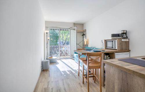 a kitchen with a table and some chairs in it at Pet Friendly Apartment in Saint-Georges-de-Didonne