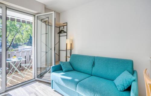 - un canapé bleu dans le salon avec une porte coulissante en verre dans l'établissement Pet Friendly Apartment, à Saint-Georges-de-Didonne