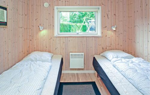 two beds in a room with a window at Lovely Home In Aabenraa With Sauna in Aabenraa