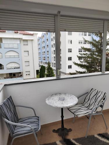 a balcony with two chairs and a table and a window at Banja Koviljaca Centar Apartman in Banja Koviljača