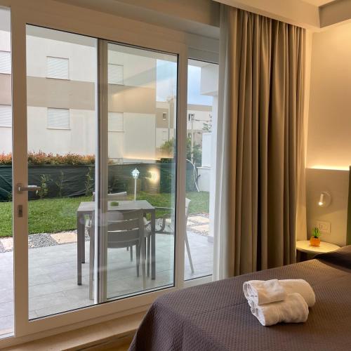 a bedroom with a sliding glass door with a table at Atlantide Suites Tropea in Tropea