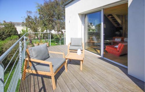 a patio with two chairs and a table on a balcony at Accueillante Maison Proche Mer in Carantec