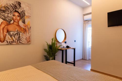 a bedroom with a painting on the wall and a mirror at Bali Seaside Sailor in Balíon