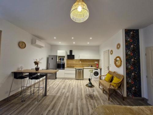 une cuisine et un salon avec une table et des chaises dans l'établissement Studio la Poulette au MAS DU COQ, à Saint-Étienne-du-Grès