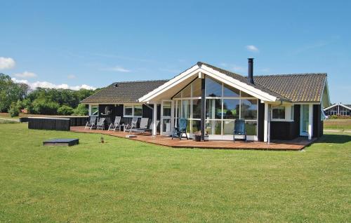 a house with a large porch and a large lawn at Cozy Home In Rudkøbing With Sauna in Spodsbjerg