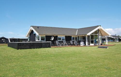 a house with a green yard in front of it at Cozy Home In Rudkøbing With Sauna in Spodsbjerg