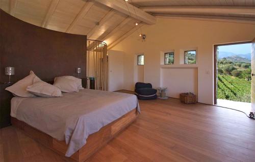 ドルチェアックアにある3 Bedroom Amazing Home In Dolceacquaの大きなベッドと大きな窓のある寝室
