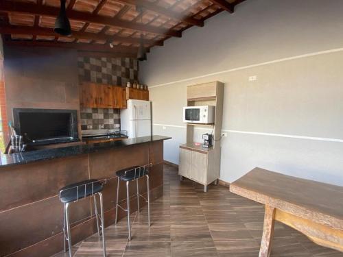 eine Küche mit einer Theke und Hockern in einem Zimmer in der Unterkunft Residencial Gil in Foz do Iguaçu
