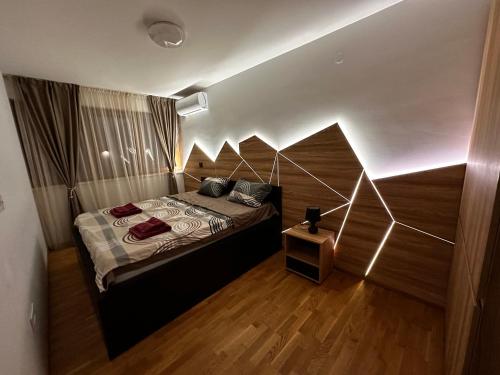 1 dormitorio con 1 cama con pared geométrica en MAR Residence 14, en Niš