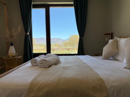 a bedroom with a bed with two towels on it at Voyage House in the countryside Polen in Korçë