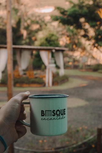 a hand holding a coffee cup with the words boston earthquake at Cabana Bosque Encantado I in Santa Teresa
