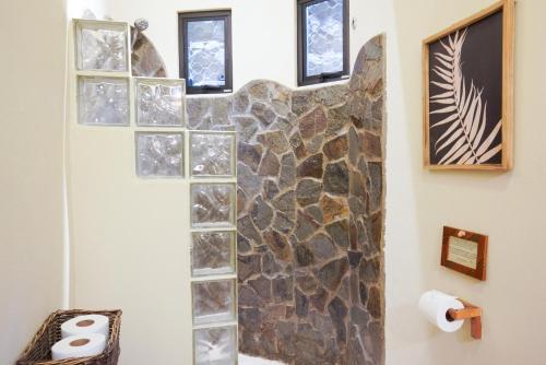 a bathroom with a stone cross on the wall at Casa Marbella in Santa Teresa Beach
