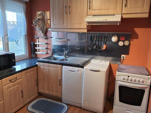 une cuisine avec un évier et une cuisinière dans l'établissement L'escapade, à Carolles