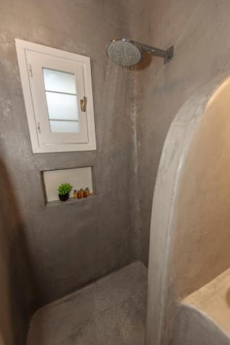 a bathroom with a shower with a sink and a window at Stylish Mykonian apartment Semi-Private huge Pool in Houlakia