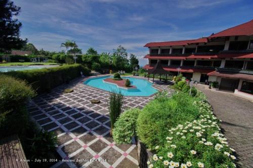 峇圖拉登的住宿－皇后花園酒店，一座带游泳池和大楼的度假村