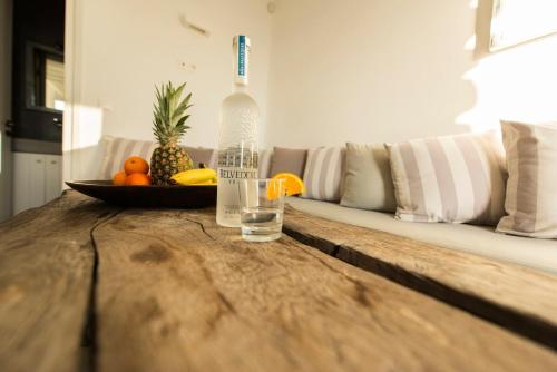 a bottle of water and a bowl of fruit on a table at Stylish Mykonian apartment Semi-Private huge Pool in Houlakia