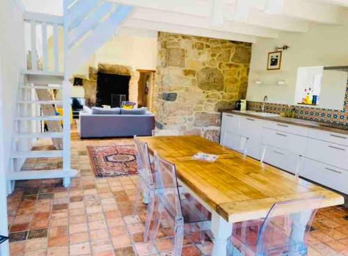une cuisine avec une table et un salon dans l'établissement Magnifique longère au cœur de Trégastel, à Trégastel