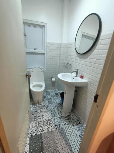a bathroom with a sink and a toilet and a mirror at Beach front B3 Marie Guest house in Jomtien Beach