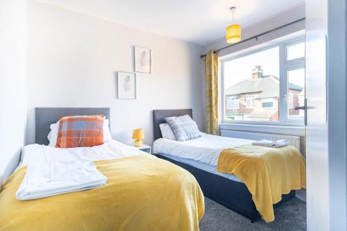 two beds in a room with a window at Royal Retreat in Redcar