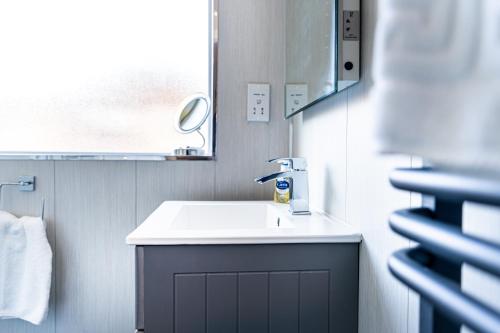 a bathroom with a white sink and a mirror at Royal Retreat in Redcar