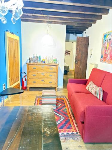 a living room with a red couch and a dresser at Casa Torrazzo in Pisogne
