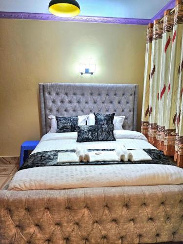 a large bed with a large headboard in a bedroom at Nelimah Hosts in Machakos
