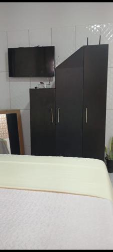 a bedroom with a bed and a tv in a room at Casa Marajó Centro de Belém COP30 in Belém