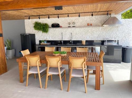 - une cuisine avec une table à manger en bois et des chaises dans l'établissement Casa Praiana Litoral, à Camaçari
