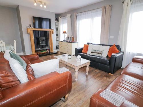 a living room with two leather couches and a coffee table at Loistin Coimin in Ballybofey