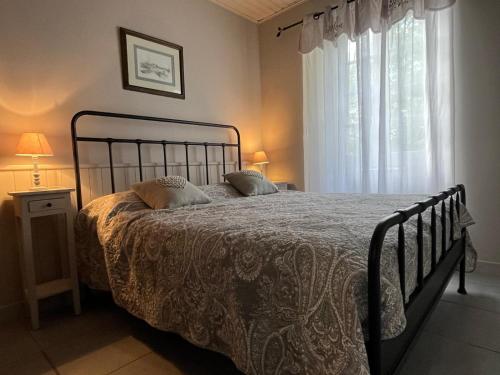 une chambre avec un lit et une fenêtre dans l'établissement Le Clos des Lilas, Gîtes de Charme, à Daglan