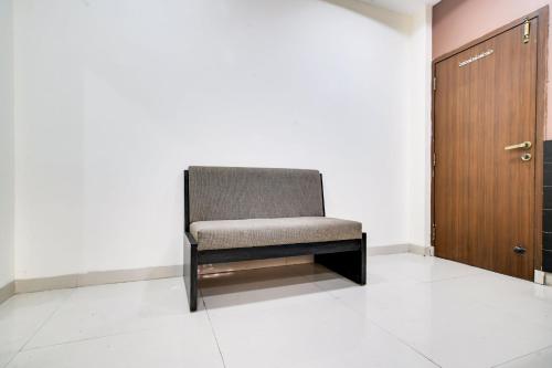 a chair sitting in a room next to a door at Super Collection O Indore Near Omax City 1 in Indore