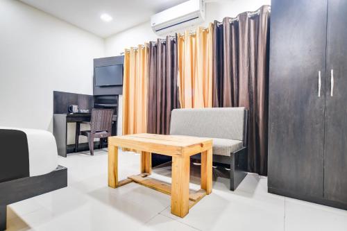 a room with a table and a chair and curtains at Super Collection O Indore Near Omax City 1 in Indore