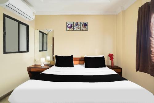 a bedroom with a large white bed and two windows at Super Hotel O Pithampur Formerly Ganga Residency in Akolia