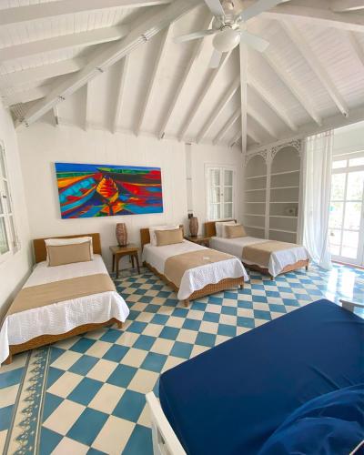 a room with three beds on a checkered floor at Hotel Agua Azul Beach Resort in Baru