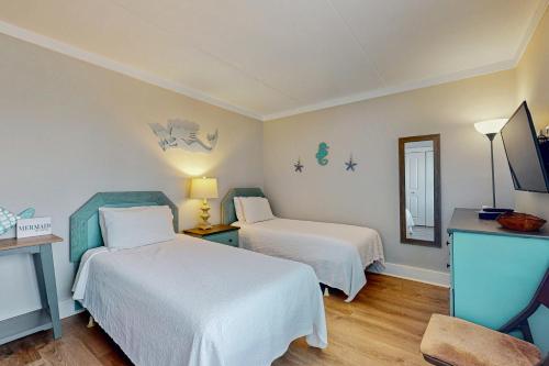 a hotel room with two beds and a mirror at Island Winds East 411 in Gulf Shores