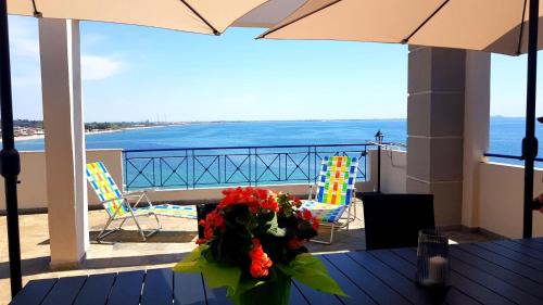 a table with a bouquet of flowers on a balcony at La Casa di Anastasia - Panorama Nea Karvali in Néa Karváli