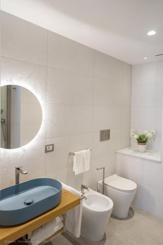 a bathroom with a blue sink and a toilet at Onda del Mare in Mazzeo