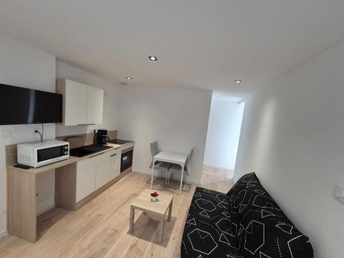 un salon avec un canapé et une cuisine dans l'établissement Appartement proche cure thermale, à Bains-les-Bains