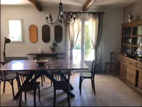une salle à manger avec une table et des chaises en bois dans l'établissement Maison avec Studio indépendant, à LʼIsle-sur-la-Sorgue